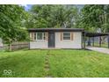 Well-maintained one-story home with gray brick, wood shutters, and a covered parking area at 360 Richie Ave, Indianapolis, IN 46234