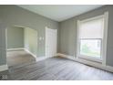 Inviting living room with hardwood floors, large window, and an open doorway at 410 Plum St, Frankton, IN 46044
