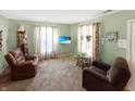 Cozy living room with comfortable armchairs, floral curtains, and a modern television display at 4329 Rutgers Dr # 40B, Anderson, IN 46013