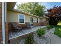 Inviting front porch with two chairs and small table, complemented by decorative stone landscaping and mature bushes at 453 N 275 E, Columbus, IN 47203