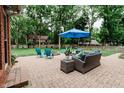 Inviting backyard patio with comfortable seating and a bright blue umbrella for outdoor enjoyment at 46 Hawthorne Ct, Carmel, IN 46033