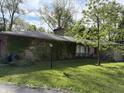 Ranch style home with ivy-covered exterior, featuring a green lawn and mature landscaping at 4609 Andover Rd, Indianapolis, IN 46226