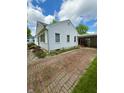 Quaint home with a brick driveway leading to covered parking and tidy yard at 472 N 17Th St, Noblesville, IN 46060