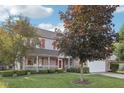 Beautiful two-story home with brick accents, a cozy front porch, mature trees, and a well-maintained lawn at 5269 Deer Creek Dr, Indianapolis, IN 46254