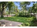 Spacious backyard with mature trees providing shade and privacy at 5460 N Park Dr, Indianapolis, IN 46220