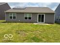 View of the backyard with the home and sliding glass door at 6926 Trey Dr, Indianapolis, IN 46113