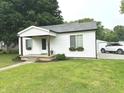 Charming single-story home with white siding, a well-manicured lawn, and flower boxes adorning the windows at 712 W Main St, Thorntown, IN 46071