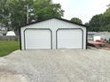 A spacious two car detached garage with white doors and black trim at 712 W Main St, Thorntown, IN 46071
