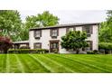 Charming two-story home with a well-manicured lawn, dark shutters, flower boxes, and a welcoming front door at 7743 Camelback Dr, Indianapolis, IN 46250