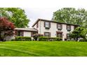 Charming two-story home with a well-manicured lawn, dark shutters, flower boxes, and a welcoming front door at 7743 Camelback Dr, Indianapolis, IN 46250