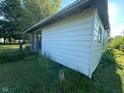 The back of the vintage home features wood siding and a small porch with a wood railing at 815 N 12Th St, Elwood, IN 46036