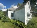 View of side of home, features wood siding, covered windows and greenery at 815 N 12Th St, Elwood, IN 46036