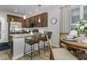 Modern kitchen features stainless steel appliances, granite counters, and a breakfast bar with barstool seating at 8568 Goldfinch Rd, Brownsburg, IN 46112