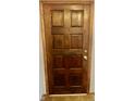 Elegant wooden front door with classic panel design and shiny brass hardware at 8875 N Goat Hollow Rd, Mooresville, IN 46158