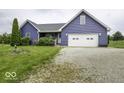 Lovely blue home with a two-car garage, a statue on the lawn, and a long gravel driveway at 911 Centennial Rd, Martinsville, IN 46151