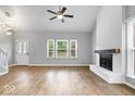 Bright living room showcases a painted brick fireplace, wood floors, and large windows for natural light at 9385 Helmsdale Dr, Indianapolis, IN 46256
