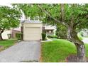 Attached garage and landscaped front yard with mature tree adding curb appeal to this lovely home at 9477 Aberdare N Dr, Indianapolis, IN 46250