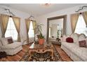 Cozy living room with decorative accents, natural light, wood flooring, and a large mirror at 10601 Adam Dr, Indianapolis, IN 46231