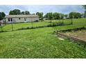 Spacious fenced backyard, perfect for gardening or outdoor activities with garden boxes in the yard at 10694 W Hickory Ct, Quincy, IN 47456