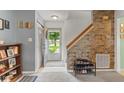 Inviting entryway featuring a brick accent wall, staircase, and an open view of the outdoors at 11532 Glenn Abbey Ln, Indianapolis, IN 46235