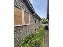 Exterior of a home with a boarded-up window and stone siding at 1214 Wallace Ave, Indianapolis, IN 46201