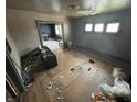 Shows an unkept living room with hardwood floors, trim and poor light from the windows at 1226 Hiatt St, Indianapolis, IN 46221