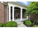 Inviting front porch framed by white pillars and lush greenery at 15410 Mission Hills Dr, Carmel, IN 46033
