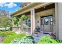 Inviting covered front porch with hanging plants and colorful landscaping at 15529 Mission Hills Dr, Carmel, IN 46033
