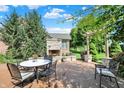 Outdoor patio features a stone fireplace, dining table, and comfortable seating at 15529 Mission Hills Dr, Carmel, IN 46033