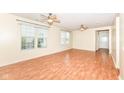 Bright, open living room with wood-look flooring, neutral walls and two ceiling fans at 15946 Marsala Dr, Fishers, IN 46037