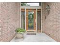 Elegant front entryway with a decorative wreath, a potted plant, and a stylish front door with glass panes at 1870 Broadleaf Ct # 10, Greenwood, IN 46143