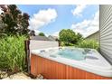 Relax in this backyard hot tub, surrounded by privacy landscaping and under the beautiful blue sky at 2020 Treving Dr, Cicero, IN 46034