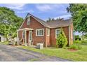 Charming brick home featuring a covered porch, well-maintained yard, and AC unit at 241 Wehmeier St, Columbus, IN 47201