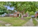 Charming brick home with a well-manicured lawn and a large tree providing ample shade at 241 Wehmeier St, Columbus, IN 47201