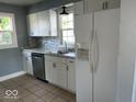 Bright kitchen features white cabinets, stainless steel appliances, and tile backsplash at 2507 S Keystone Ave, Indianapolis, IN 46203