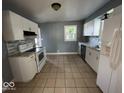 Spacious kitchen with white appliances, tile floors, and modern backsplash at 2507 S Keystone Ave, Indianapolis, IN 46203