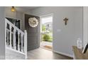 Bright foyer with a decorative wreath on the front door and staircase to the left at 2733 Lamar Dr, Whitestown, IN 46075