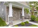 Inviting front porch with stone columns and decorative wreath, creating a welcoming entrance to the home at 2733 Lamar Dr, Whitestown, IN 46075