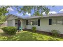 Exterior view of the home showing a well kept lawn, window shutters, and landscaped bushes at 3019 E Berwyn St, Indianapolis, IN 46203
