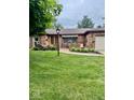 Charming brick home with a cozy front porch and professionally landscaped garden beds at 3130 Taylor Rd, Columbus, IN 47203