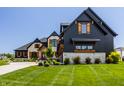 Picture of a stylish home featuring a blend of dark wood and light stone, enhanced by a green lawn at 3675 Dartmoor Way, Zionsville, IN 46077