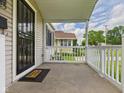 Inviting covered porch with white railings, offering neighborhood views at 4025 Main St, Anderson, IN 46013