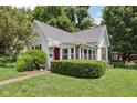 A cozy home featuring red accents, a brick pathway, and a well-manicured front yard at 409 N Sycamore St, Martinsville, IN 46151