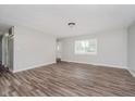 Bright living room featuring wood-look flooring, a large window, and neutral paint at 4514 Priscilla Ave, Indianapolis, IN 46226