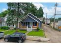 A quaint home displays its front facade, complete with a yard, landscaping, and nearby street at 517 N Alton Ave, Indianapolis, IN 46222