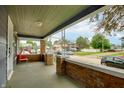 Relaxing covered porch with brick accents offering ample space and neighborhood views at 517 N Alton Ave, Indianapolis, IN 46222