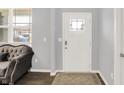 Bright entryway features a decorative front door, neutral walls, hardwood floors, and ample natural light from a nearby window at 5812 Flat Hill Dr, Indianapolis, IN 46239