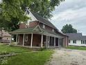 Classic brick home featuring a welcoming covered porch, ideal for relaxing and enjoying the outdoors at 590 W Washington St, Martinsville, IN 46151