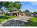 Brick home features a wrap around porch, graveled driveway and a detached red garage at 590 W Washington St, Martinsville, IN 46151