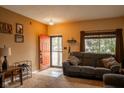 Cozy living room with a comfortable sofa, a bright red door and window with blinds for natural light at 6585 Dunsdin Dr, Plainfield, IN 46168